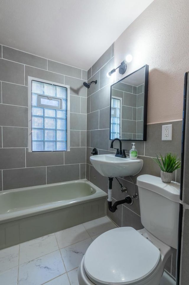 full bathroom with toilet, tiled shower / bath, and sink