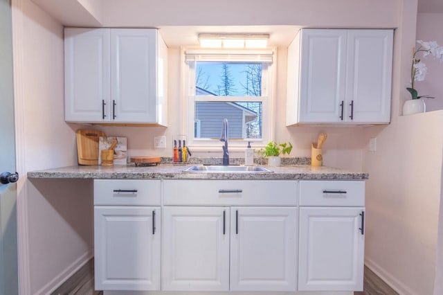 kitchen with sink, white cabinetry, and hardwood / wood-style floors