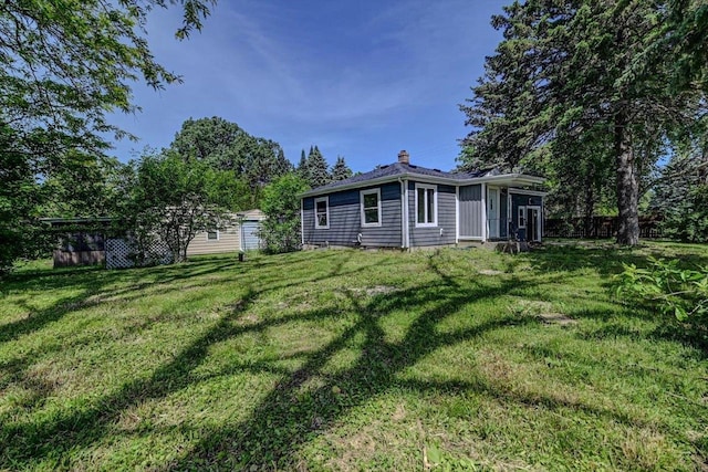 rear view of property featuring a yard