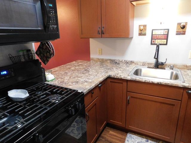 kitchen with black appliances, light stone countertops, sink, and dark wood-type flooring