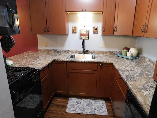 kitchen with black appliances, light stone countertops, dark hardwood / wood-style floors, and sink