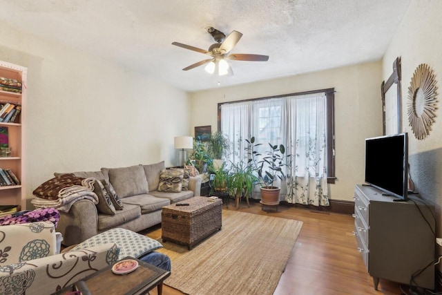 living room with a textured ceiling, ceiling fan, and hardwood / wood-style flooring