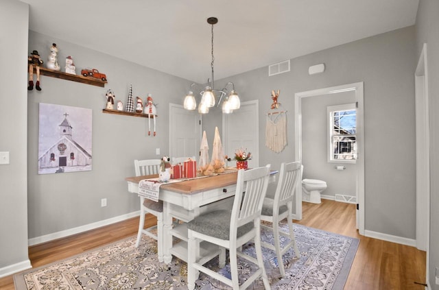 dining area with a chandelier and hardwood / wood-style flooring