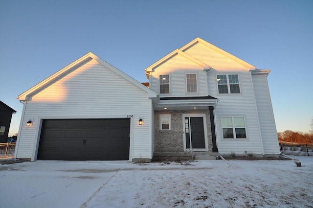 traditional home with an attached garage, fence, and brick siding