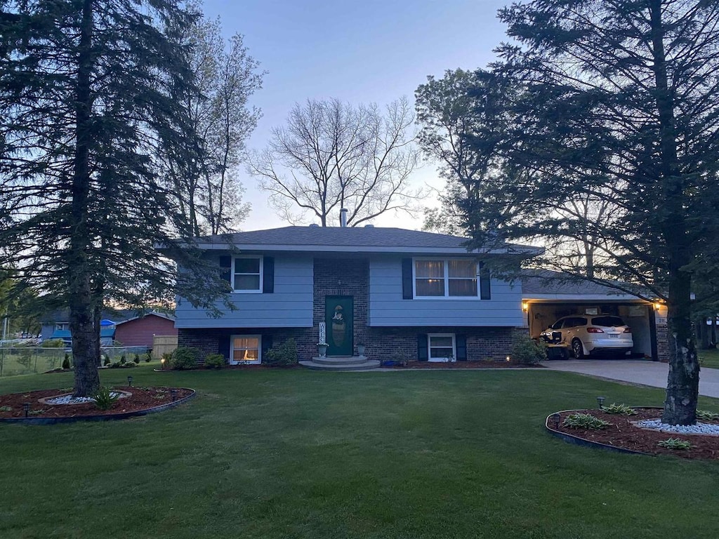 split foyer home featuring a carport and a front yard