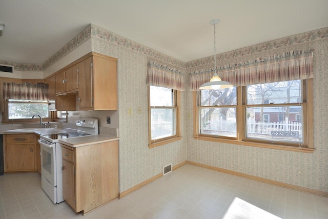 kitchen with hanging light fixtures, a wealth of natural light, white electric stove, and sink