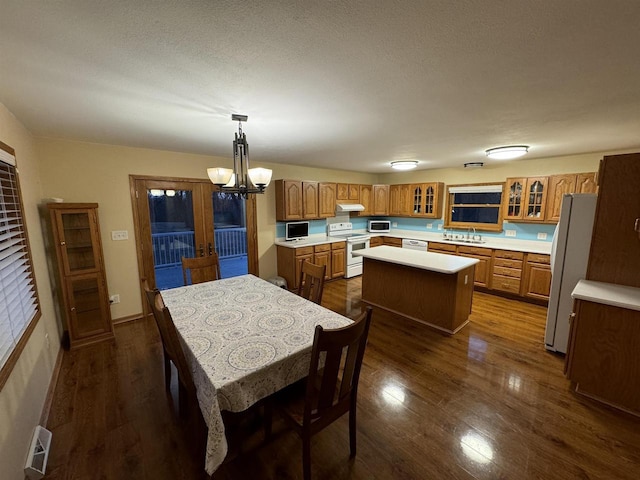 dining room featuring an inviting chandelier, dark hardwood / wood-style floors, french doors, a textured ceiling, and sink