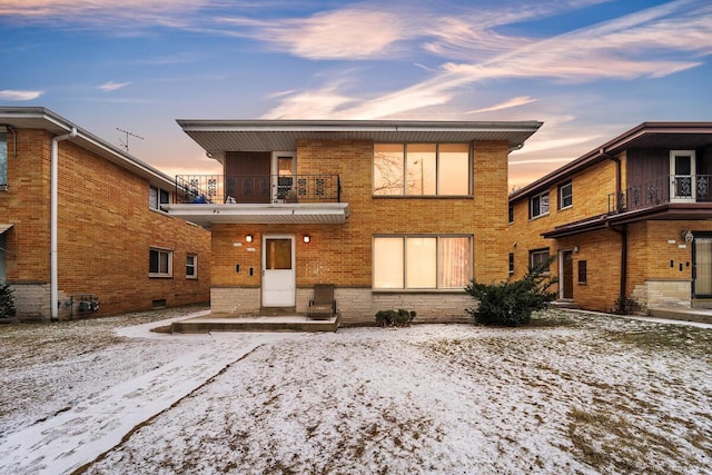 snow covered property with a balcony