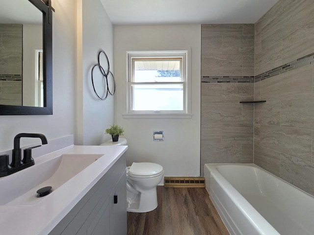 full bathroom with wood-type flooring, toilet, vanity, and tiled shower / bath