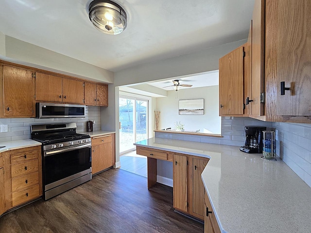 kitchen featuring ceiling fan, stainless steel appliances, dark hardwood / wood-style flooring, and tasteful backsplash