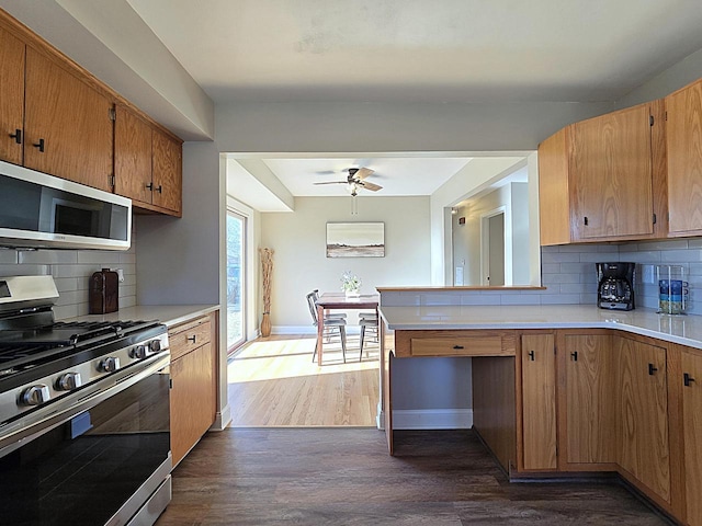 kitchen featuring tasteful backsplash, ceiling fan, appliances with stainless steel finishes, and dark wood-type flooring