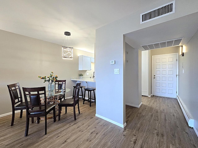 dining room featuring baseboard heating and wood-type flooring