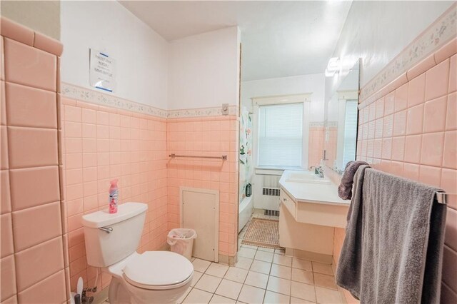 1010 S Farwell St, Eau Claire, WI 54701 - bathroom featuring toilet, vanity, tile walls, tile patterned floors, and radiator heating unit