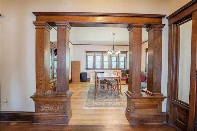 1010 S Farwell St, Eau Claire, WI 54701 - dining space with decorative columns, a notable chandelier, and light wood-type flooring