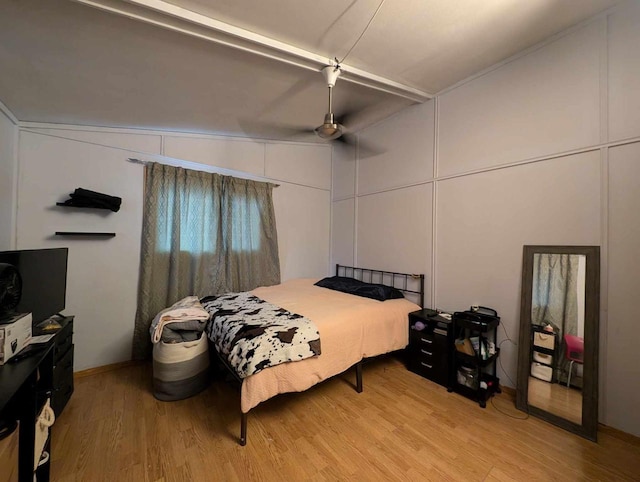 bedroom featuring ceiling fan, light wood-type flooring, and lofted ceiling