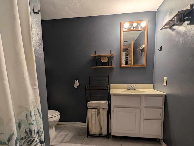 bathroom with toilet, tile patterned floors, and vanity