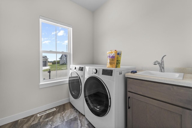 clothes washing area featuring cabinets, washer and dryer, a wealth of natural light, and sink