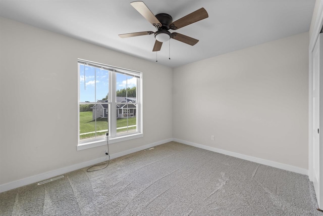 carpeted spare room featuring ceiling fan