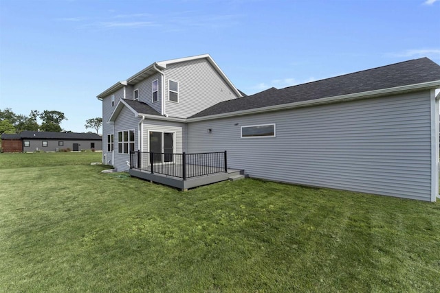 rear view of property with a wooden deck and a yard