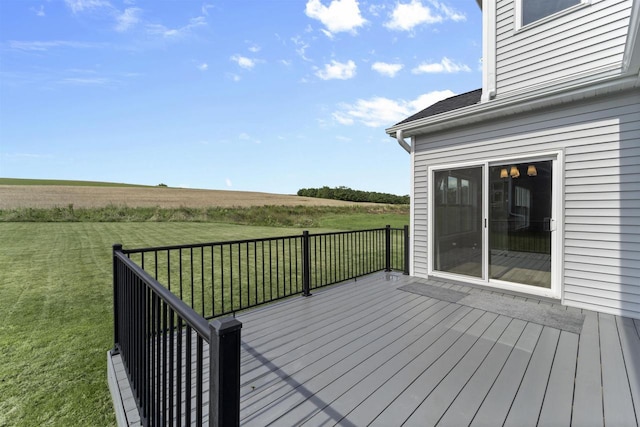 wooden terrace featuring a rural view and a yard