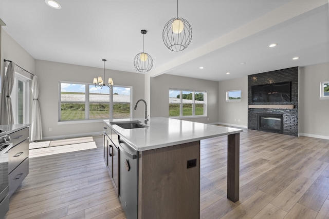 kitchen featuring an inviting chandelier, an island with sink, appliances with stainless steel finishes, decorative light fixtures, and sink