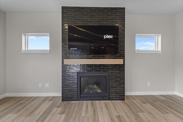 room details with hardwood / wood-style floors and a large fireplace