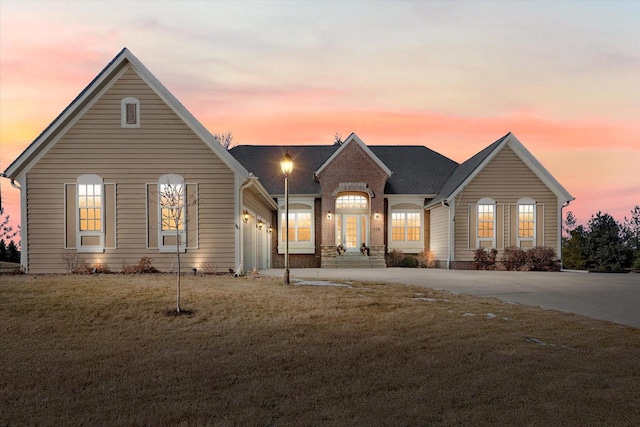 view of front of property with a garage and a lawn