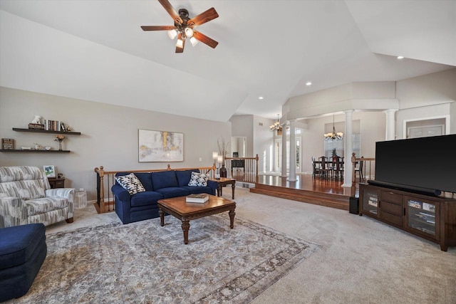 living room featuring lofted ceiling, ceiling fan with notable chandelier, carpet floors, and ornate columns