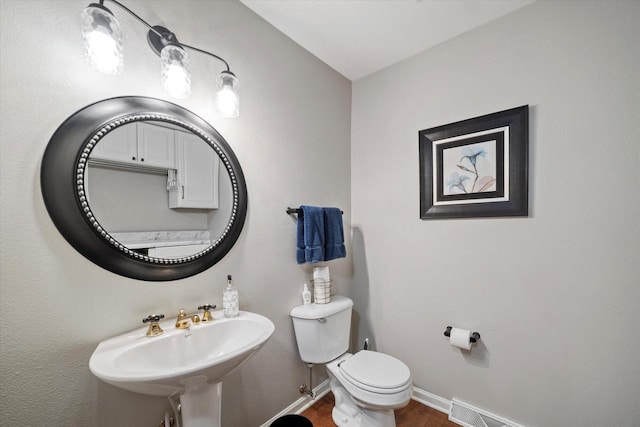 bathroom featuring toilet, hardwood / wood-style flooring, and sink