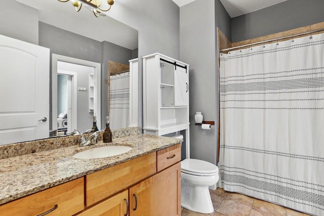 bathroom featuring toilet, tile patterned flooring, and vanity