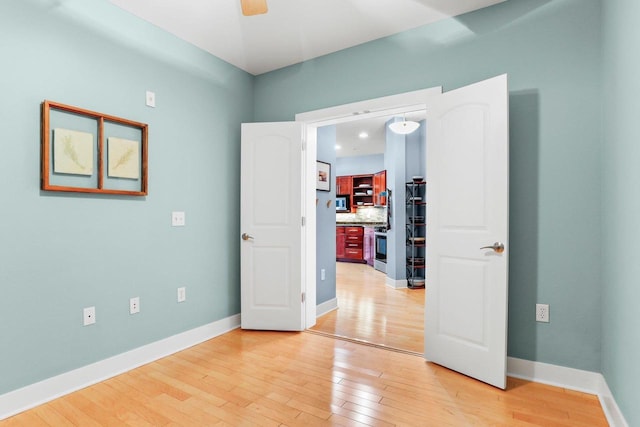 spare room featuring light hardwood / wood-style flooring and ceiling fan