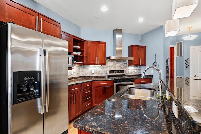 kitchen featuring wall chimney exhaust hood, sink, tasteful backsplash, dark stone countertops, and stainless steel appliances