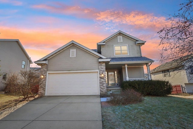 view of front of house with a garage, a lawn, and covered porch