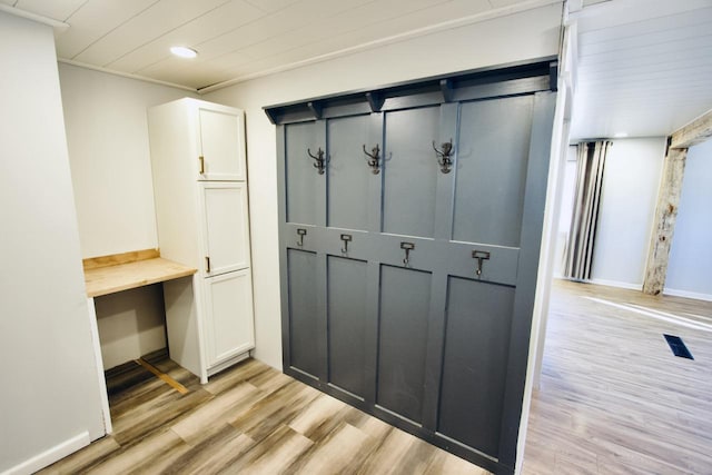 mudroom with light hardwood / wood-style floors and ornamental molding