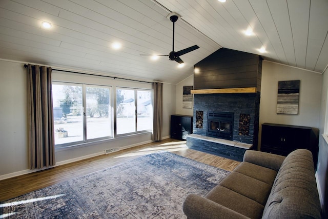 living room featuring wood ceiling, a stone fireplace, ceiling fan, vaulted ceiling, and hardwood / wood-style flooring