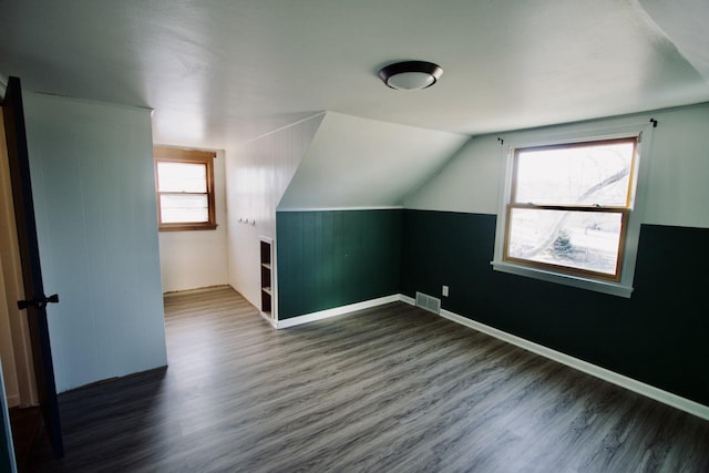 additional living space with dark hardwood / wood-style flooring and lofted ceiling