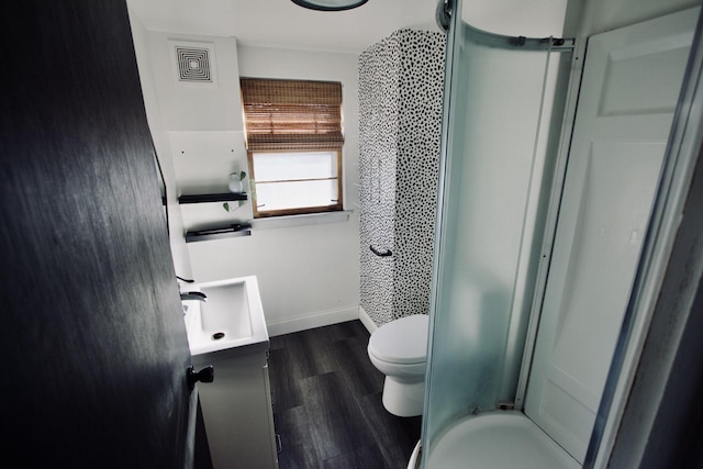 bathroom featuring toilet, walk in shower, hardwood / wood-style flooring, and vanity