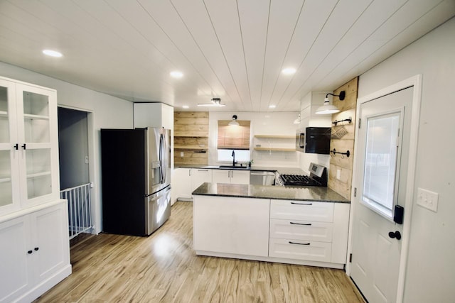 kitchen featuring white cabinetry, light hardwood / wood-style floors, kitchen peninsula, stainless steel appliances, and sink