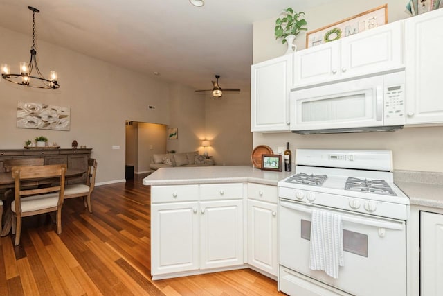 kitchen with white cabinetry, white appliances, pendant lighting, and ceiling fan with notable chandelier