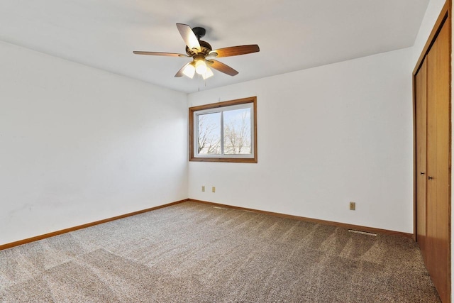 spare room with baseboards, carpet, and ceiling fan