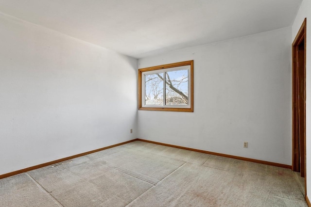 spare room featuring visible vents, baseboards, and light carpet