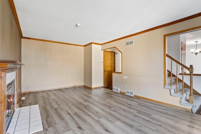 unfurnished living room featuring wood finished floors, visible vents, and a tile fireplace