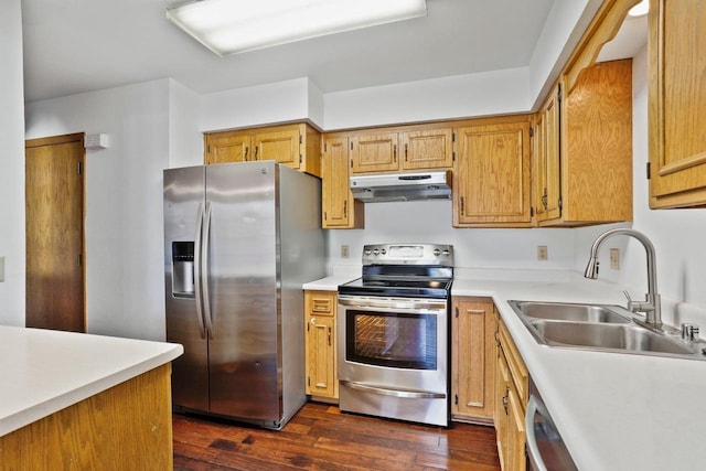 kitchen featuring a sink, under cabinet range hood, light countertops, appliances with stainless steel finishes, and dark wood-style flooring