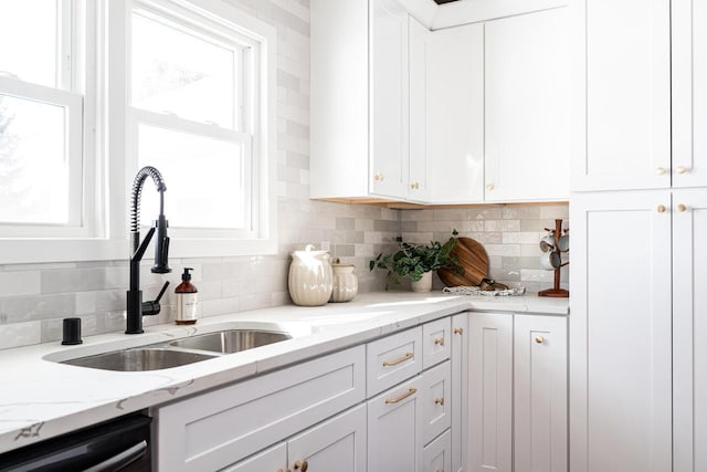 kitchen with white cabinetry, backsplash, and dishwashing machine