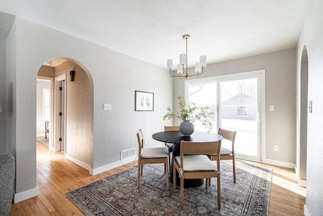 dining area featuring light hardwood / wood-style floors and a chandelier