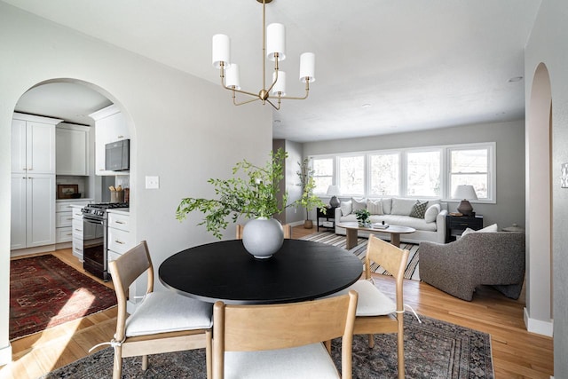 dining area featuring a notable chandelier and light wood-type flooring