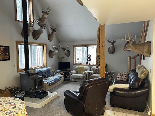 living room with light colored carpet, vaulted ceiling, plenty of natural light, and a wood stove