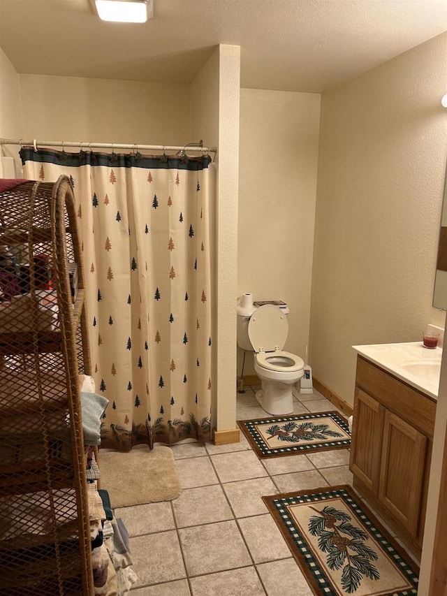 bathroom featuring toilet, vanity, a shower with curtain, and tile patterned flooring