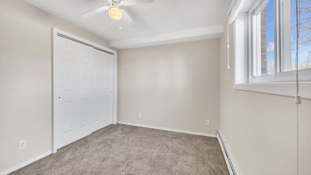 unfurnished bedroom featuring a baseboard radiator, light colored carpet, ceiling fan, and a closet