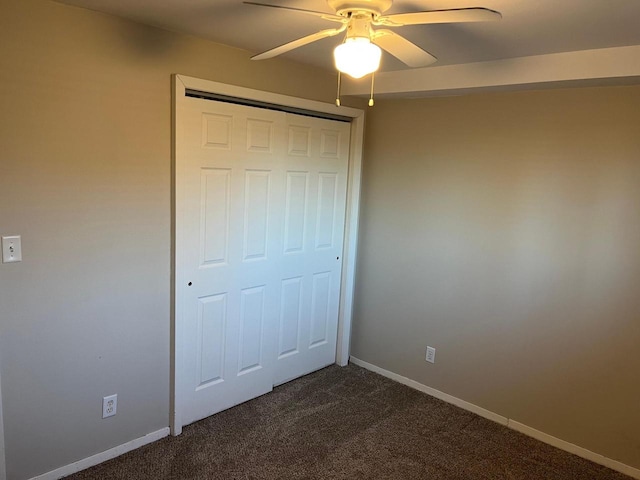 unfurnished bedroom featuring ceiling fan, a closet, and dark colored carpet